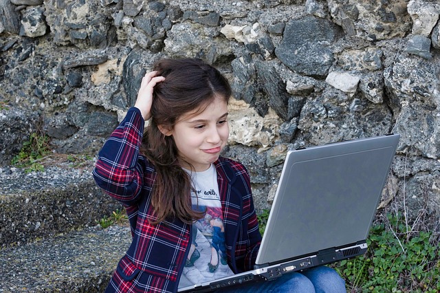 ksichtící se holčička na počítač